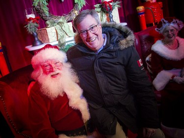 Mayor Jim Watson sits on Santa's knee for a photo Saturday afternoon.