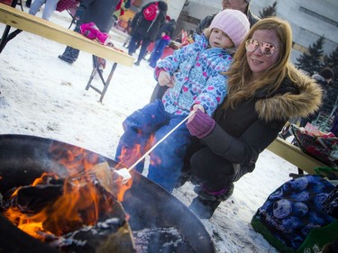 Four-year-old Ayala Shea and her mother Tara Macintosh roast a marshmallow together.