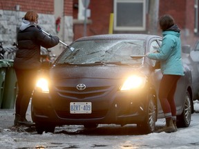 Two women clear the ice off their car in Ottawa Friday Dec 27, 2019.    Tony Caldwell