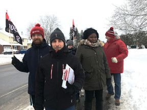 Teachers at A.Y. Jackson Secondary School in Kanata hold an information picket on Wednesday. Science teacher Paris Vasiliou, in grey hat in front, says the government's plan to increase class sizes is his major concern.