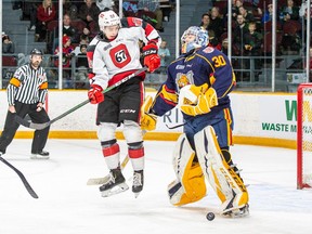 Jack Quinn, middle, of the Ottawa 67's tries to jump out of the way as a team fires a shot on net against Barrie Colts goaltender Arturs Silovs (30) during an Ontario Hockey League contest against the Barrie Colts at TD Place arena on Saturday, Dec. 14, 2019. The 67's won the game 7-2. Photo by Valerie Wutti/Ottawa 67's.