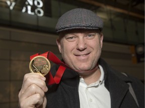 Following a long flight Team Canada assistant coach and Ottawa 67's head coach André Tourigny shows off the gold medal upon arriving at the Ottawa Airport. Canada beat Team Russia 4-3 at the World Junior Championships in the Czech Republic on Sunday.