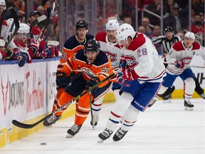 Patrick Russell #52 of the Edmonton Oilers moves the puck past Mike Reilly #28 of the Montreal Canadiens at Rogers Place on December 21, 2019, in Edmonton, Canada.