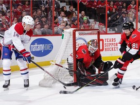 Marcus Hogberg of the Ottawa Senators makes a save on a wrap around attempt by Nick Suzuk of the Montreal Canadiens as Ron Hainsey defends the net in the first period at Canadian Tire Centre on Saturday.