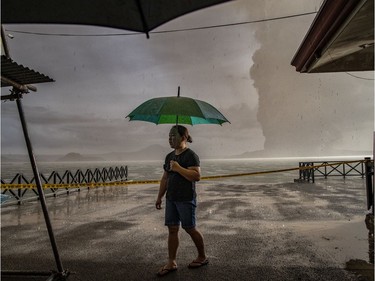 A resident walks along a lakeside as Taal Volcano erupts on January 12, 2020 in Talisay, Batangas province, Philippines. Local authorities have begun evacuating residents near Taal Volcano as it began spewing ash up to a kilometer high Sunday afternoon. The Philippine Institute of of Volcanology and Seismology has raised the alert level to three out of five, warning of the volcano's continued "magmatic unrest."