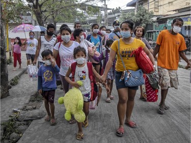 Residents fleeing Taal Volcano's eruption arrives at an evacuation center on January 13, 2020 in Santo Tomas, Batangas province, Philippines. The Philippine Institute of of Volcanology and Seismology raised the alert level to four out of five, warning that a hazardous eruption could take place anytime, as Manila's international airport suspended flights and authorities began evacuating tens of thousands of people from the area.