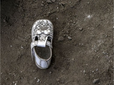 baby's shoe is seen scattered, left behind by residents who briefly returned to the island to retrieve belongings, is seen covered in volcanic ash from Taal Volcano's eruption on January 14, 2020 in Taal Volcano Island, Batangas province, Philippines. The Philippine Institute of of Volcanology and Seismology raised the alert level to four out of five, warning that a hazardous eruption could take place anytime, as authorities have evacuated tens of thousands of people from the area. An estimated $10 million worth of crops and livestock have been damaged by the on-going eruption, according to the country's agriculture department.