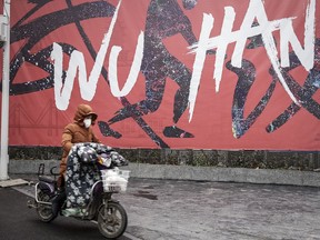 A woman wears a mask while riding an electric bicycle on January 22, 2020 in Wuhan, Hubei province, China. A new infectious coronavirus known as "2019-nCoV" was discovered in Wuhan as the number of cases rose to over 400 in mainland China.