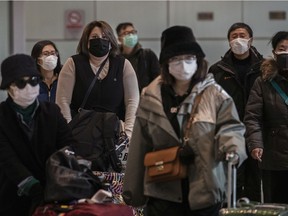 Passengers wear protective masks as they arrive at Beijing Capital Airport on January 30, 2020 in Beijing, China.