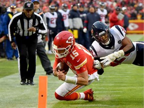 Quarterback Patrick Mahomes #15 of the Kansas City Chiefs dives to the 1-yard line for a first down over Justin Reid #20 of the Houston Texans in the third quarter of the AFC Divisional playoff game at Arrowhead Stadium on January 12, 2020 in Kansas City, Missouri.