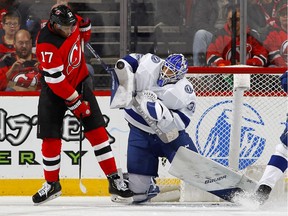 Curtis McElhinney #35 of the Tampa Bay Lightning makes a save in the first period under pressure from Wayne Simmonds #17 of the New Jersey Devils at Prudential Center on January 12, 2020 in Newark, New Jersey.
