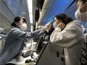 A passenger receives a temperature check before taking a flight bound for Wuhan at Spring Airlines' check-in counter at Haneda airport on January 31, 2020 in Tokyo, Japan.