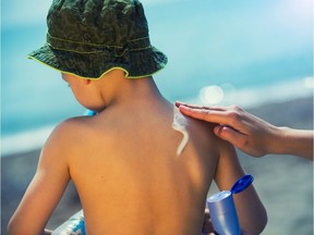 Little boy with suncream on shoulder at beach