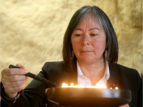 Joyce Ford, a counsellor at the centre, light the Qulliq, a soapstone oil lamp, in one of the meeting rooms.