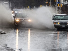 Cars make their way through a giant puddle on Richmond Road as Ottawa was hit with heavy rain Saturday January 11, 2020.