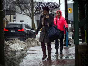 Pedestrians hustle down Richmond Road as Ottawa was hit with heavy rain Saturday January 11, 2020.