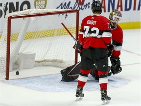 Defenceman Thomas Chabot looks on as the puck sits behind Senators netminder Marcus Hogberg for the overtime winning goal by Blackhawks captain Jonathan Toews.