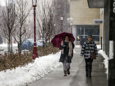 People hustle through the uOttawa campus as rain turned to snow on Saturday afternoon.