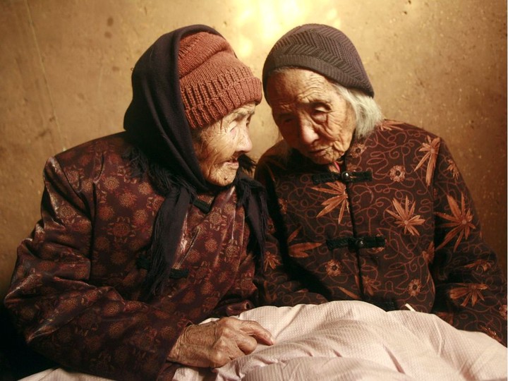  Chinese 104-year-old twins, Cao Daqiao (senior, R) and Cao Xiaoqiao talk at home in Weifang, east China’s Shandong province on November 29, 2009. According to the Shanghai Guinness World Records, this twin sisters, who were born in 1905, were the oldest living twins in the world as of 2009. STR / AFP VIA GETTY IMAGES