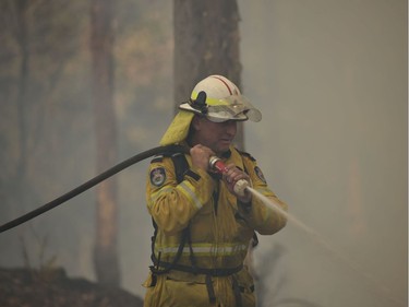 Firefighters tackle a bushfire near Batemans Bay in New South Wales on January 3, 2020. - With temperatures expected to rise well above 40 degrees Celsius (104 Fahrenheit) again on January 4, a state of emergency has been declared across much of Australia's heavily populated southeast in an unprecedented months-long bushfire crisis.