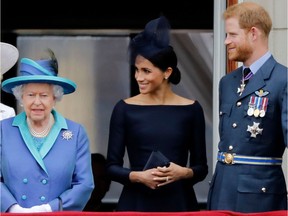 This file photo from July 10, 2018 shows  Queen Elizabeth, Meghan, Duchess of Sussex, and Prince Harry, Duke of Sussex watching a military fly-past to mark the centenary of the Royal Air Force (RAF).