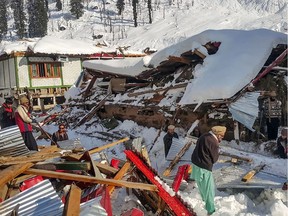 Local residents remove debris of a collapsed house following heavy snowfall that triggered an avalanche in Neelum Valley, in Pakistan-administered Kashmir on January 14, 2020. - At least 42 people were killed and 21 wounded after heavy snowfall and rain hit Pakistan-administered Kashmir and the country's southwest, officials said.