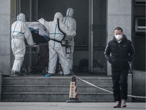 Medical staff members carry a patient into the Jinyintan hospital, where patients infected by a mysterious SARS-like virus are being treated, in Wuhan in China's central Hubei province on January 18, 2020.