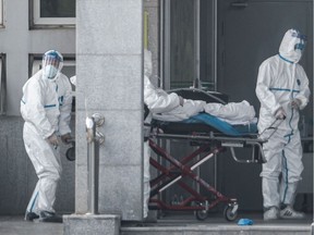 Medical staff members carry a patient into the Jinyintan hospital, where patients infected by a mysterious SARS-like virus are being treated, in Wuhan in China's central Hubei province on January 18, 2020.