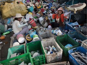 This file photo shows workers sorting out plastic bottles at a waste centre in Beijing. China will ban plastic bags in major cities and single-use straws from restaurants by the end of 2020 in a bid to cut down on waste.