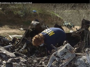 This still image taken from a January 27, 2020, video released by the National Transportation Safety Board (NTSB), shows a NTSB official inspecting the remains of a helicopter which crashed near Calabasa, California, on January 26, 2020.