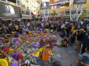 Fans gather at Staples Center in Los Angeles on Tuesday to remember the late Kobe Bryant, one of nine people who perished in a helicopter crash on Sunday. The scheduled NBA game between the Lakers and the Clippers was postponed.