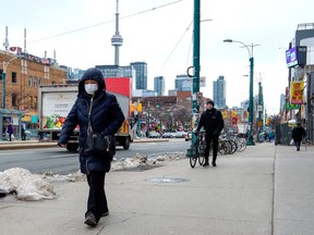 A pedestrian wears a protective mask in Toronto on Monday, January 27, 2020. Canada's first presumptive case of the novel coronavirus has been officially confirmed, Ontario health officials said Monday as they announced the patient's wife has also contracted the illness.