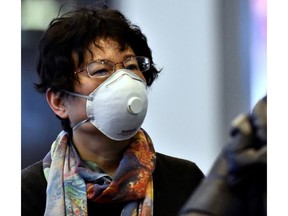 A traveler wears a mask after arriving at Vancouver International Airport on a direct flight from China on Friday.