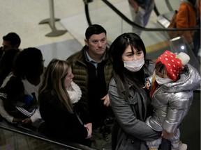 Travellers wearing masks arrive on a direct flight from China, after a spokesman from the U.S. Centers for Disease Control and Prevention (CDC) said a traveller from China had been the first person in the United States to be diagnosed with the Wuhan coronavirus, at Seattle-Tacoma International Airport in SeaTac, Washington, U.S. January 23, 2020.