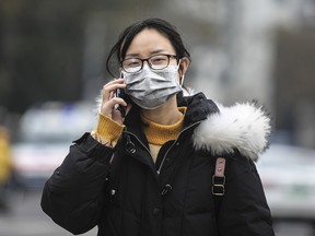 A woman wears a mask while walking past the closed Huanan Seafood Wholesale Market, which has been linked to cases of Coronavirus, on Jan. 17, 2020 in Wuhan, China.