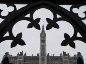 Freezing rain turns the Peace Tower white, Thursday January 24, 2019 in Ottawa. The parliamentary budget watchdog estimates the Liberal government's newly enacted income tax cut will cost $2.5 billion more than the government projects.