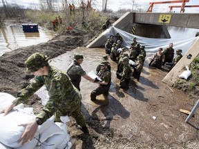 Canadian Forces members build a wall of sandbags at the underpass on Alexander Street to try to keep back floodwaters in Pembroke, Ont., on May 11, 2019. Canada's top soldier is warning that as the Army gets called out to a growing number of floods, wildfires and other natural disasters, there is a risk that work will hurt the force's ability to defend the country. An analysis by