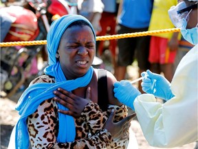 A young woman reacts as a health worker injects her with the Ebola vaccine, in Goma, Democratic Republic of Congo, August 5, 2019.