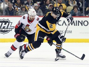 Senators winger Scott Sabourin, left, pursues Penguins defenceman during the third period of Monday's game at Pittsburgh.