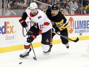 Senators winger Nick Paul moves the puck ahead of Penguins centre Teddy Blueger.