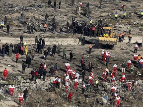 Rescue workers search the scene where an Ukrainian plane crashed in Shahedshahr, southwest of the capital Tehran, Iran, Wednesday, Jan. 8, 2020.