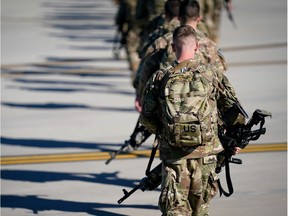 U.S. Army paratroopers assigned to the 1st Brigade Combat Team, 82nd Airborne Division, walk toward an awaiting aircraft prior to departing for the Middle East from Fort Bragg, North Carolina, U.S.