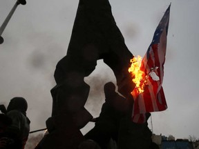 Iranians burn U.S and Israeli flags as they gather to mourn General Qassem Soleimani, head of the elite Quds Force, who was killed in a U.S. air strike at Baghdad airport, in Tehran, Iran Jan. 4, 2020.