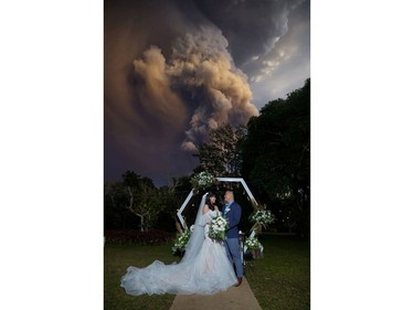 A couple attends their wedding ceremony as Taal Volcano sends out a column of ash in the background in Alfonso, Cavite, Philippines, January 12, 2020, in this image obtained from social media.