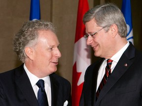 Stephen Harper is greeted by Jean Charest in 2011. The two have history.