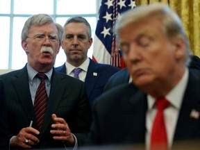 FILE PHOTO: U.S. President Donald Trump listens as his national security adviser John Bolton speaks during a presidential memorandum signing for the "Women's Global Development and Prosperity" initiative in the Oval Office at the White House in Washington, U.S., February 7, 2019.