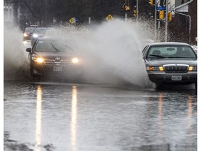 Cars splash through a giant puddle on Richmond Road as Ottawa was hit with heavy rain Jan. 11.