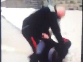 This still from a video posted on Facebook shows a Brockville police officer striking a woman who was later charged with resisting arrest.