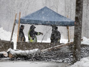 Protesters take shelter from the elements at the rail blockade in Kahnawake on Thursday morning.