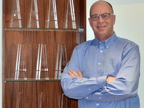 A floor-to-ceiling alcove in his home office displays some of the many award trophies Gordon Weima has received over the years.